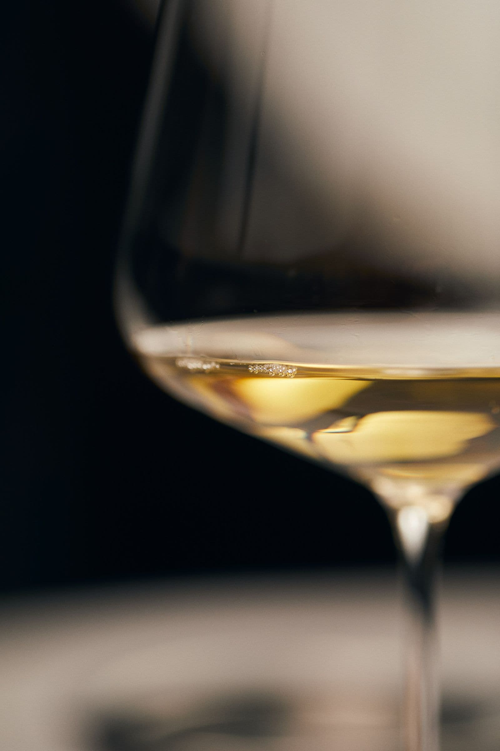 Weinglas mit goldgelbem Weißwein als Stillleben