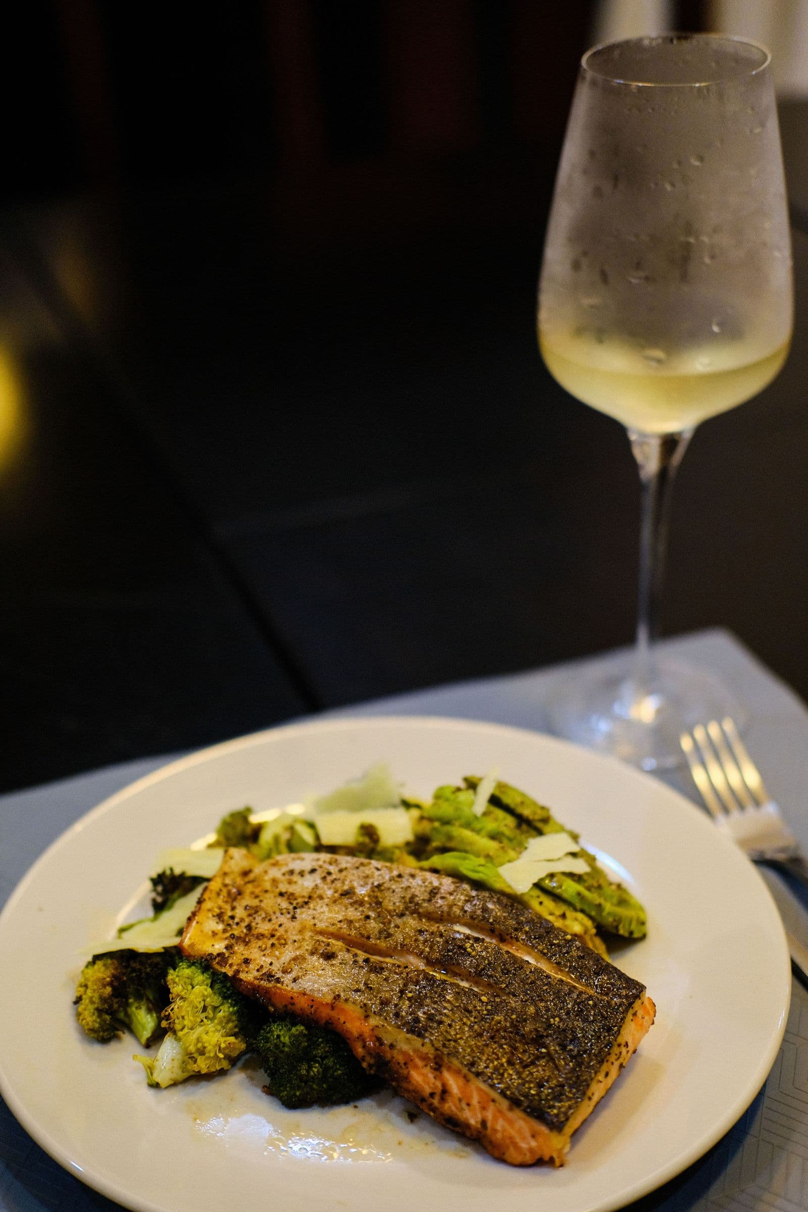 Lachsfilet mit Brokkoli und einem gekühlten Glas Weißwein